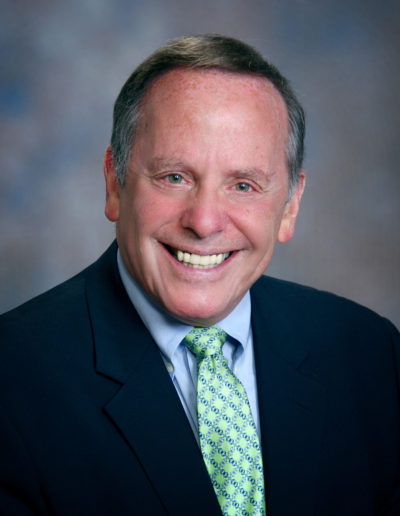 An older gentleman smiling into the camera.