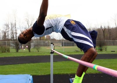 An athlete deftly leaps over a high jump pole.