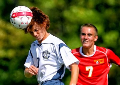 A young soccer player head-butting the ball.